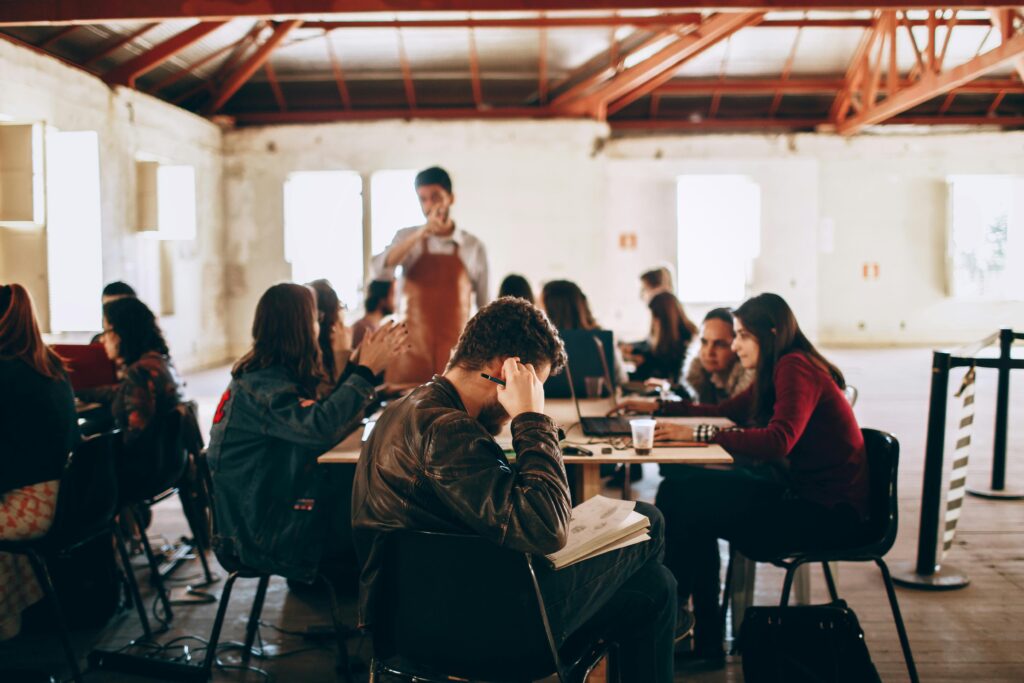 University students engaging in group study and discussion inside a classroom, focusing on teamwork and research.